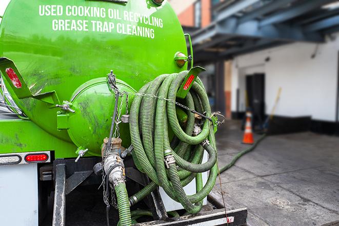 grease trap being pumped out by service technician in Benton, KS